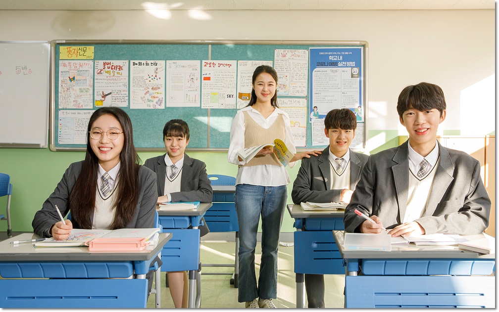 교실에서 수업을 듣는 학생들과 설명하는 교사