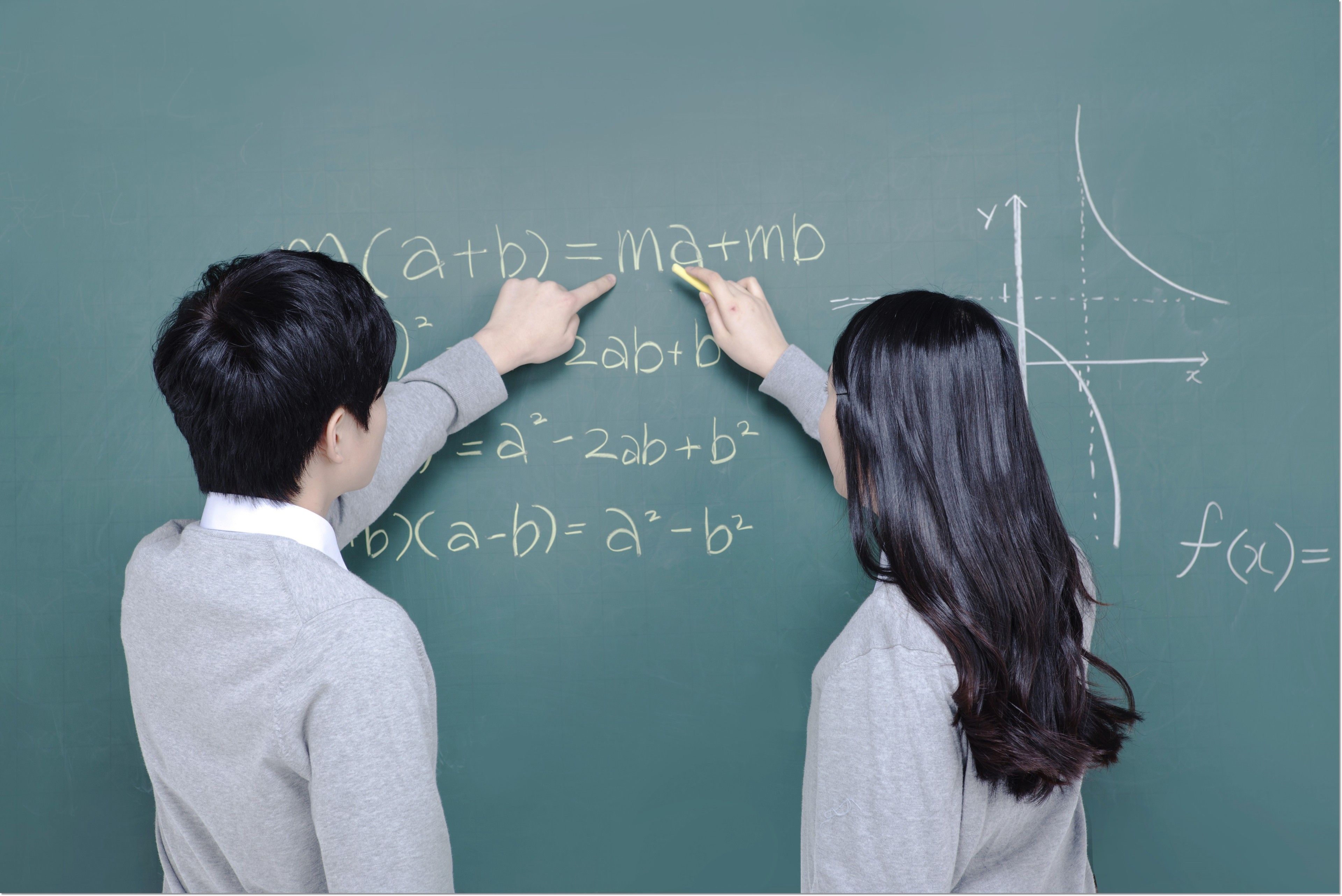 칠판의 수학식을 함께 살펴보는 학생들