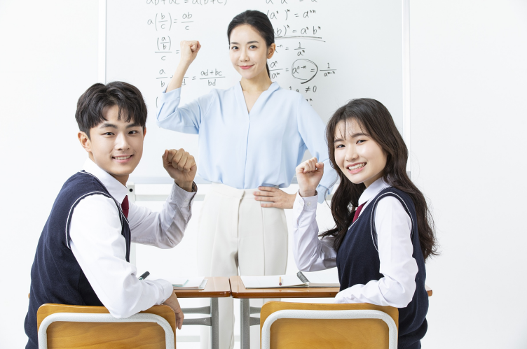 교실 책상 앞에 모인 학생들과 교사