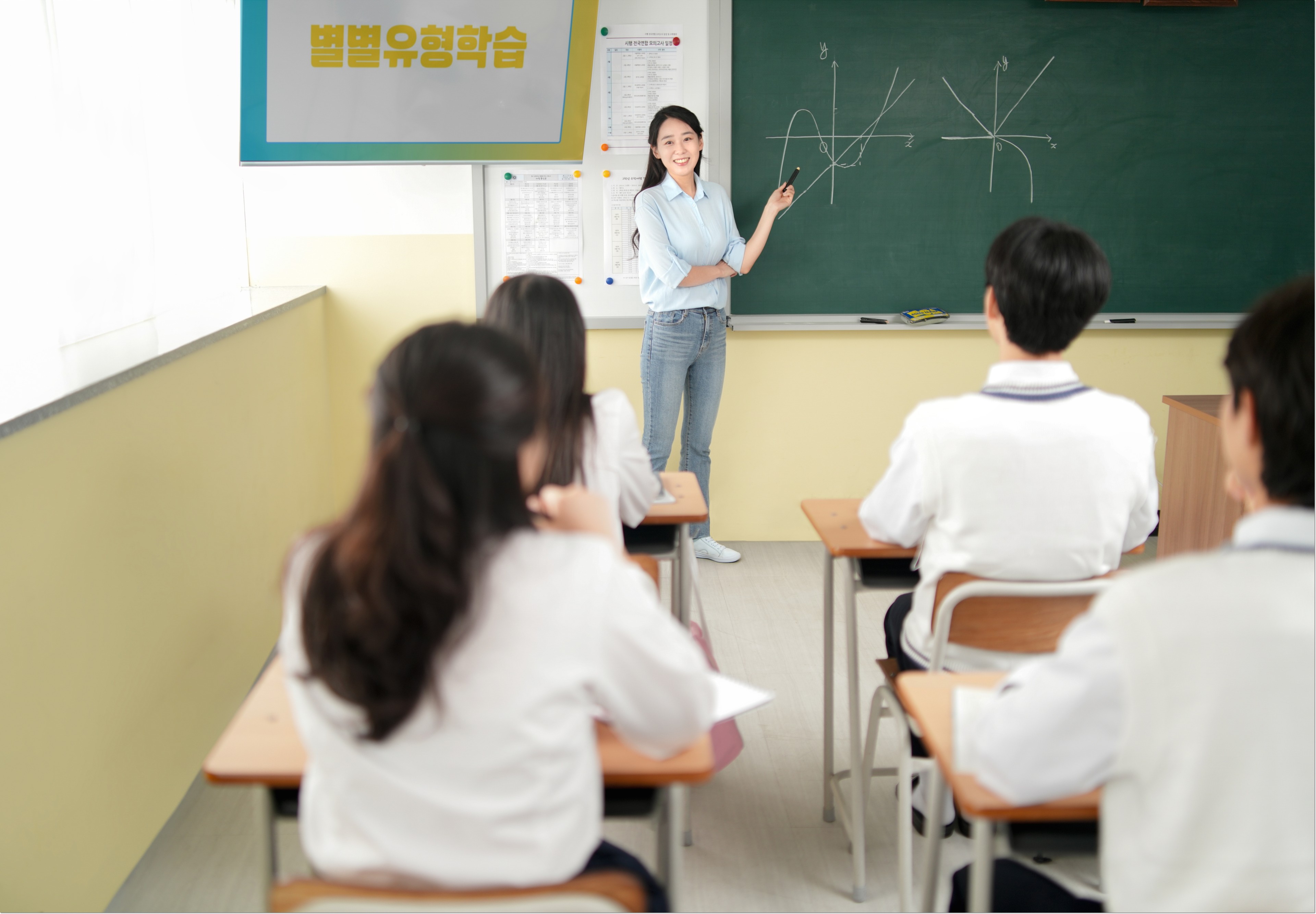 칠판 앞 설명을 듣는 교실의 학생들