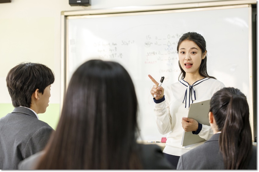 교실에서 학생들에게 설명하는 교사