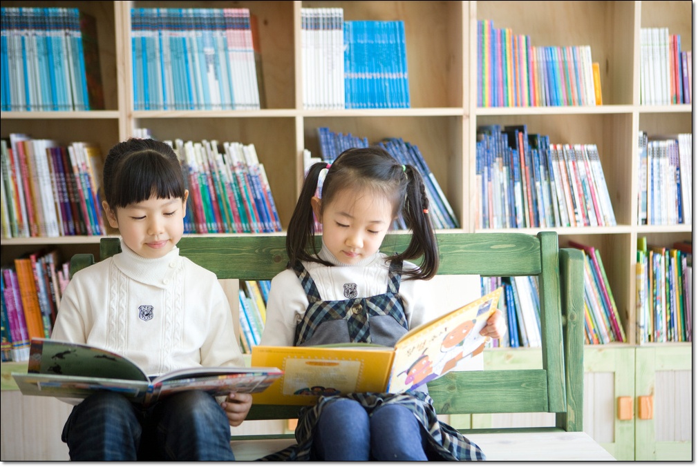 도서관에서 나란히 책을 읽는 두 학생