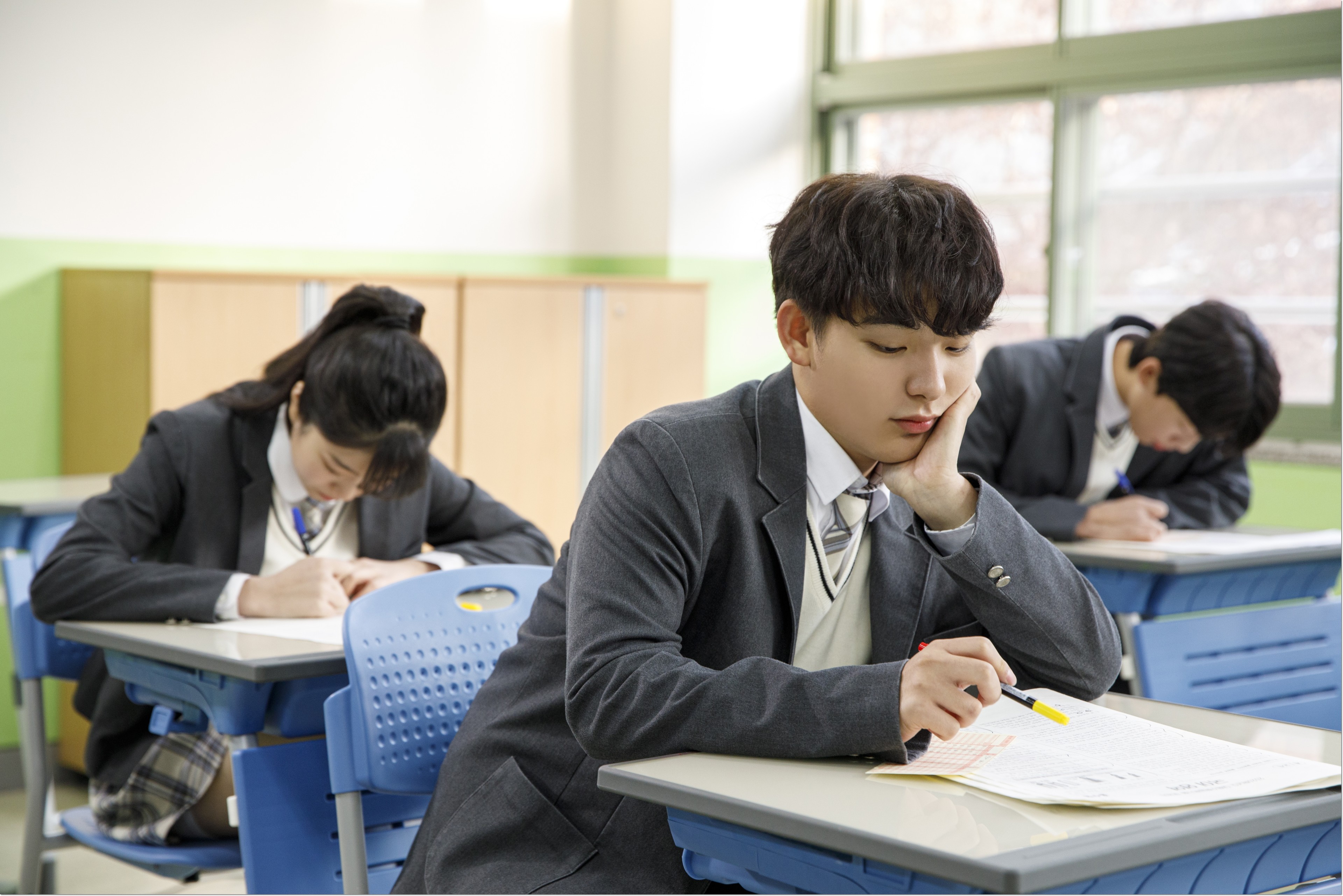 교실에서 학습 자료를 보는 두 학생