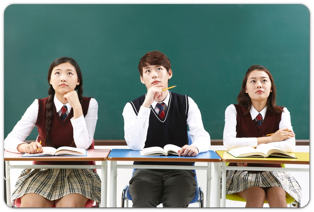 책상 앞에서 생각하는 세 학생