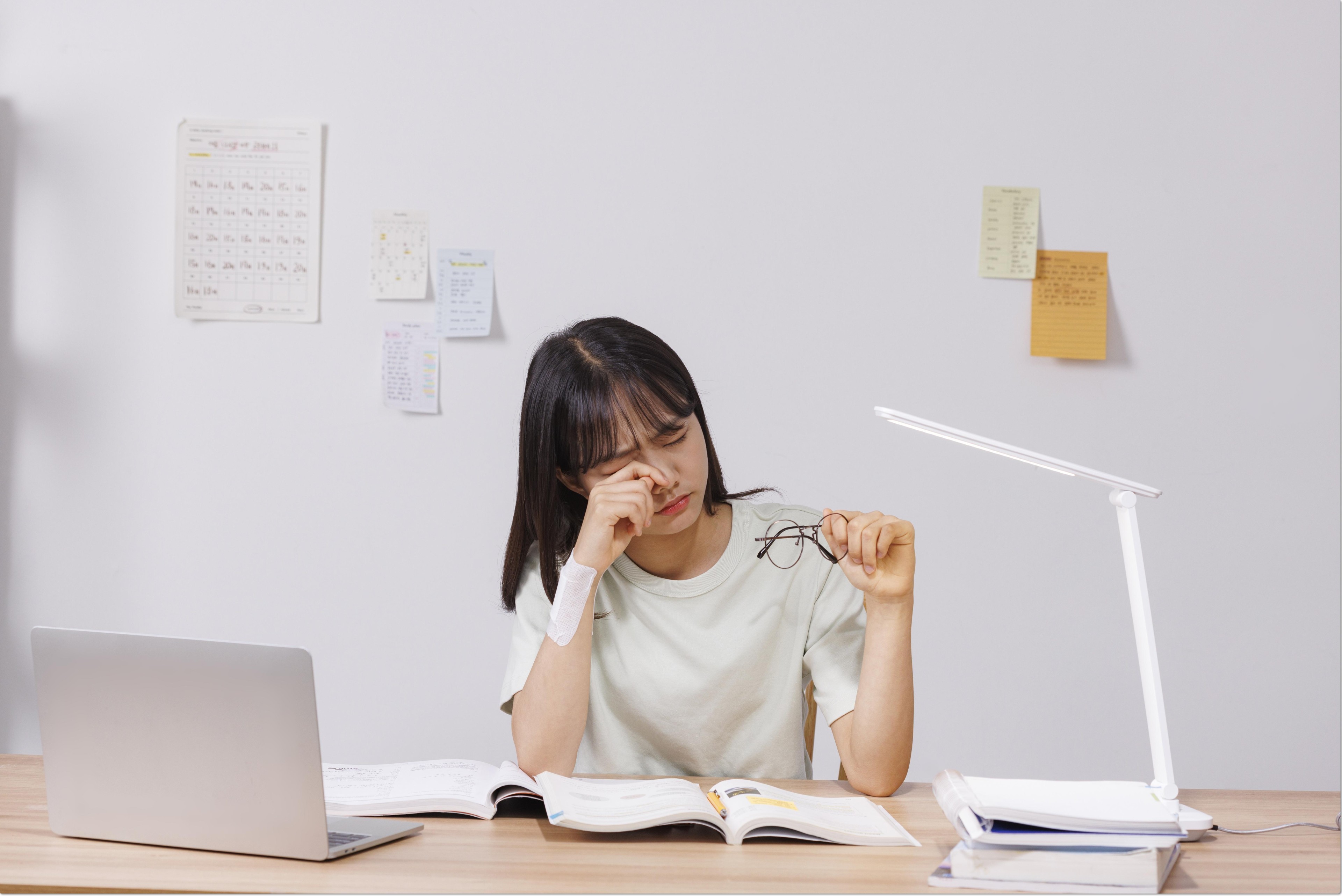 펼친 책 앞에서 잠시 쉬는 학생