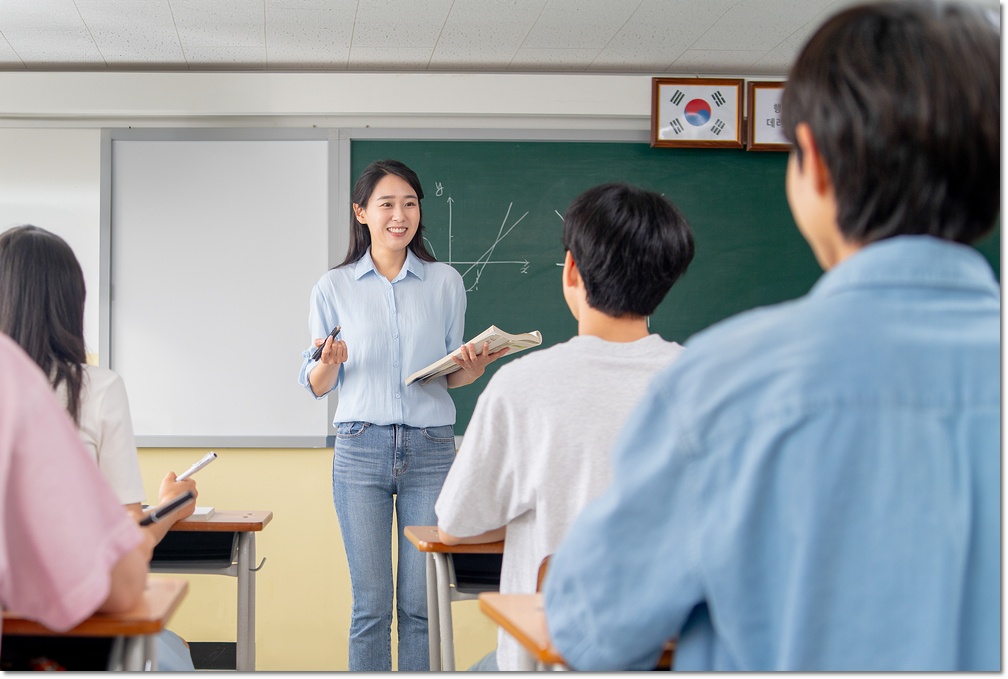 칠판 앞에서 설명하는 교사와 수업을 듣는 학생들