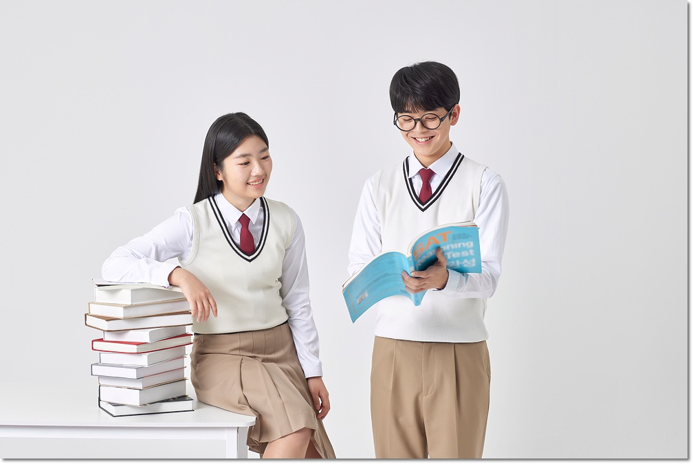 교재를 들고 대화하는 두 학생