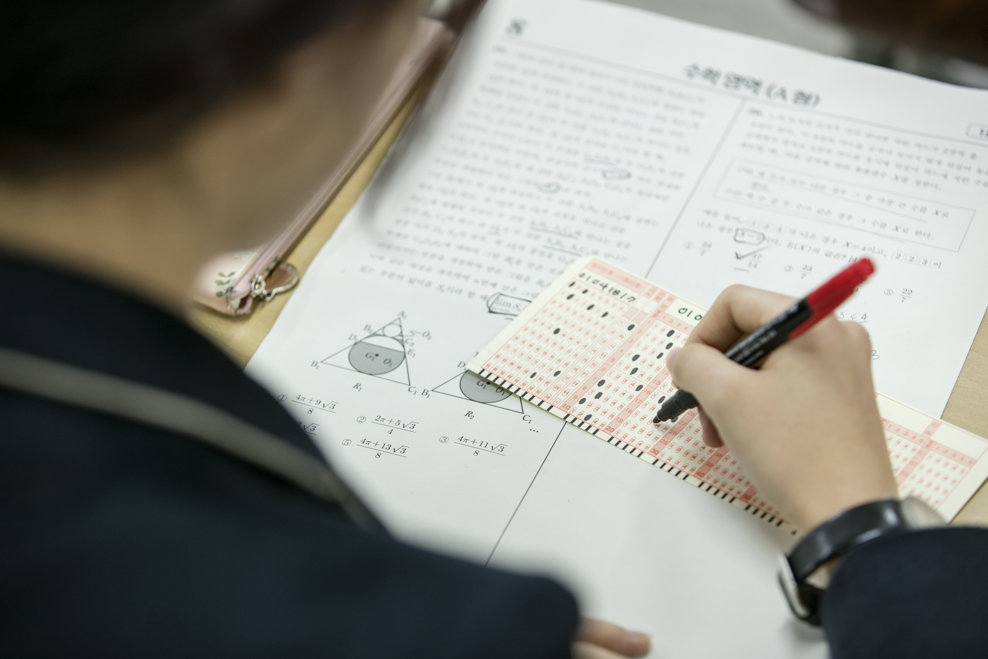 교재에 연필로 풀이를 기록하는 모습