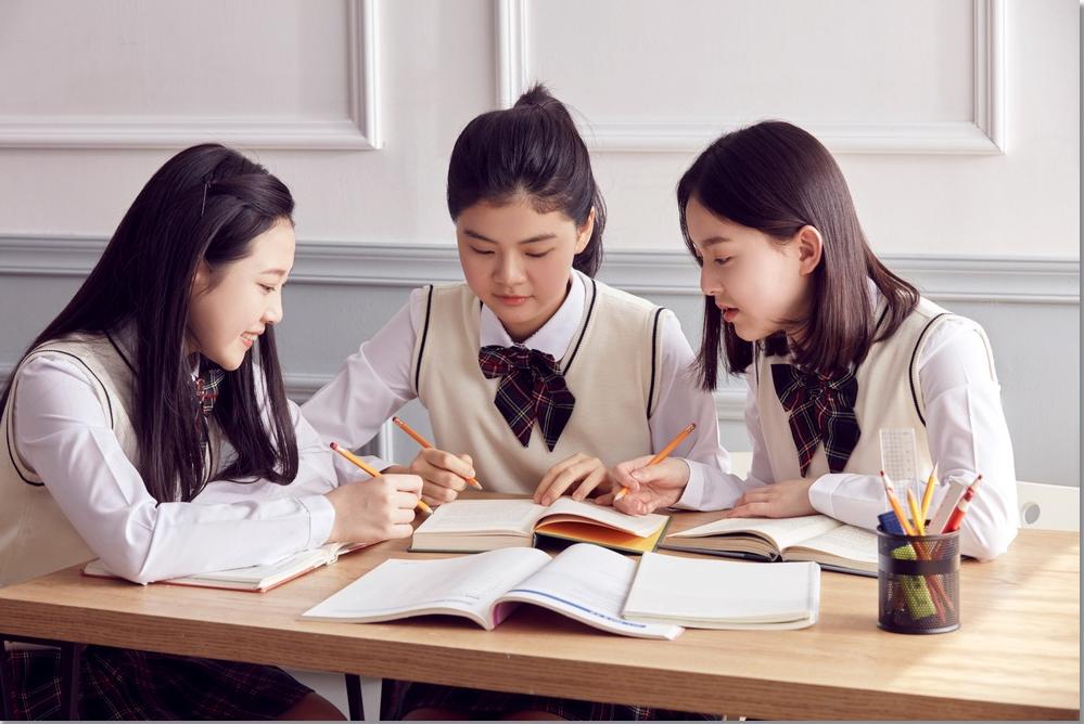 교재를 함께 보며 대화하는 세 학생